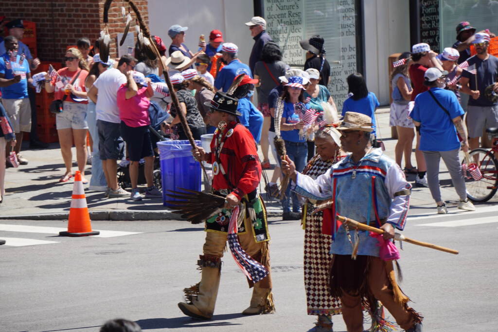 Three members of the Lenape tribe walk down the street.