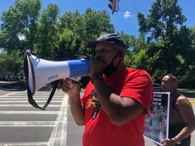 Jamal Johnson, from Germantown, protests outside Sesame Place on Saturday. Johnson and others aimed to raise awareness about what they say is discriminatory behavior from employees at the Bucks County theme park. (Emily Rizzo/WHYY)