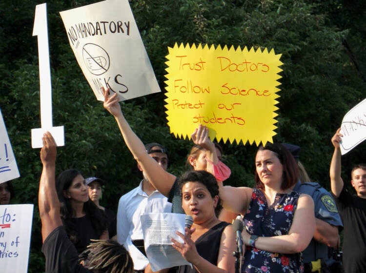 Anusha Viswanathan, July 27, 2021, speaking at a press conference in support of stricter COVID-19 safety policies, as other Central Bucks parents in the crowd shouted over her. (Emma Lee/WHYY)