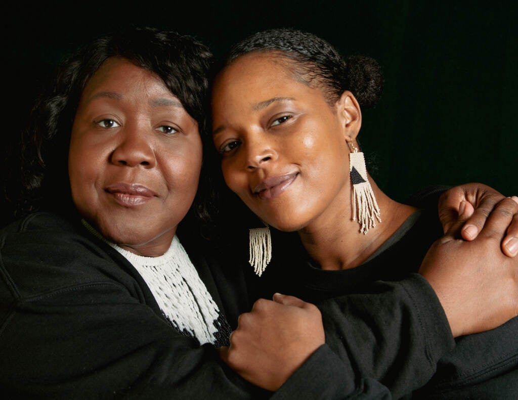 Two women embrace and face the camera.