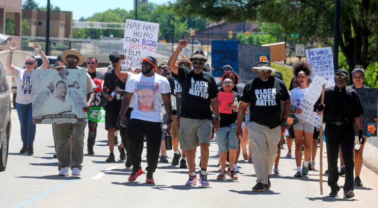 Fatal Police Shooting Ohio A group of people walks, carrying signs protesting the police shooting and death of Jayland Walker.