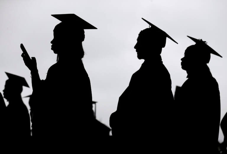 Graduates line up before the start of a community college commencement