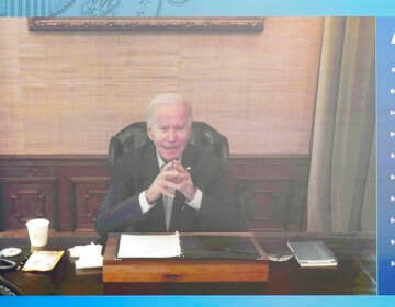 President Biden is seen on screen sitting at a desk.