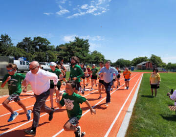 The first race gets underway in the newly-refurbished running track at Jack Curtis Stadium in Camden. (Tom MacDonald / WHYY)