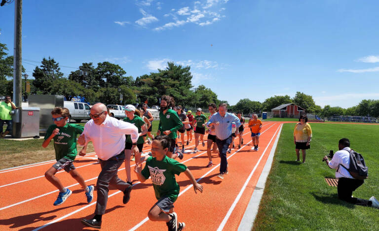 The first race gets underway in the newly-refurbished running track at Jack Curtis Stadium in Camden. (Tom MacDonald / WHYY)