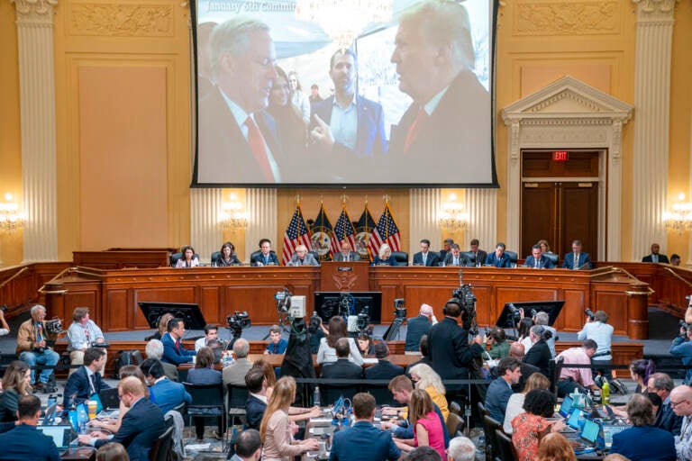 The Jan. 6 commission presents evidence below a screen which shows former President Donald Trump speaking with his Chief of Staff Mark Meadows.