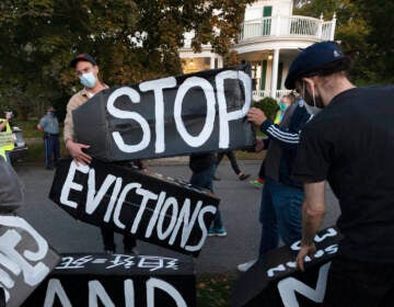 A person holds two signs that say 