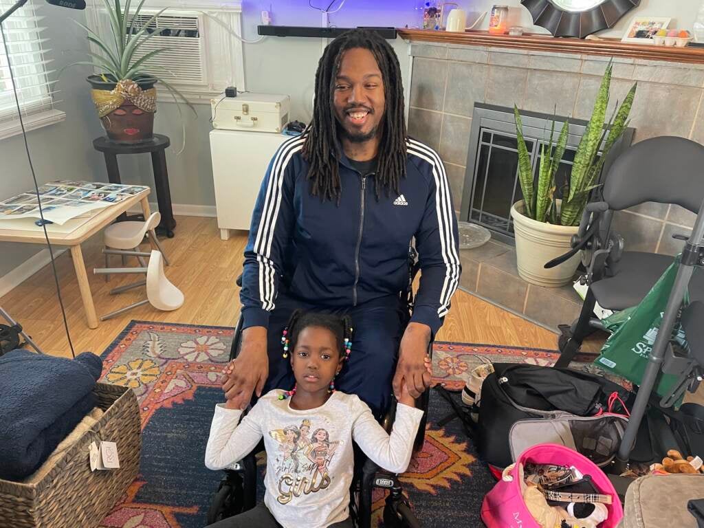 Leon Harris, a gun violence survivor, smiles with his daughter.