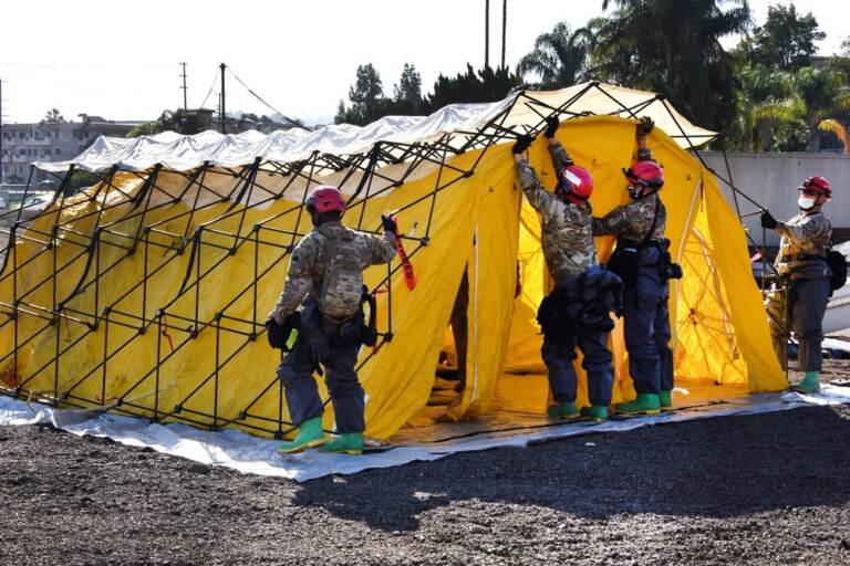 People lift up a tent