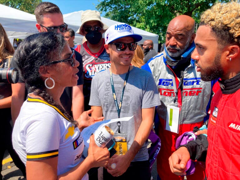 NASCAR driver Kyle Larson, center, talks with members of the Urban Youth Racing School before the start of a race on the grounds of the Please Touch Museum in Philadelphia, Friday, July 22, 2022.