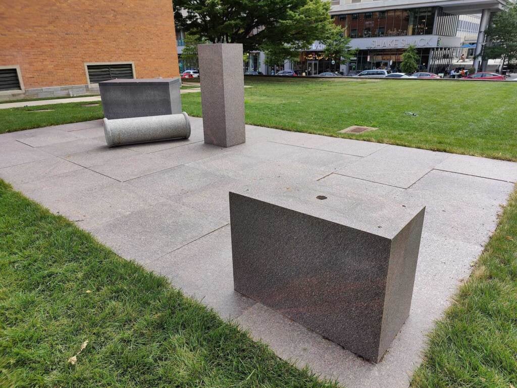 Blocks are visible as part of a sculpture installation, surrounded by grass.