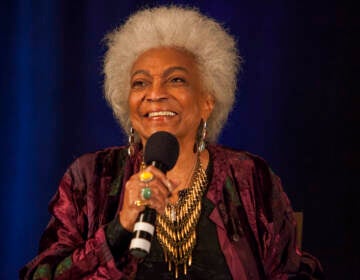 Up-close photo of Nichelle Nichols speaking with microphone in hand.