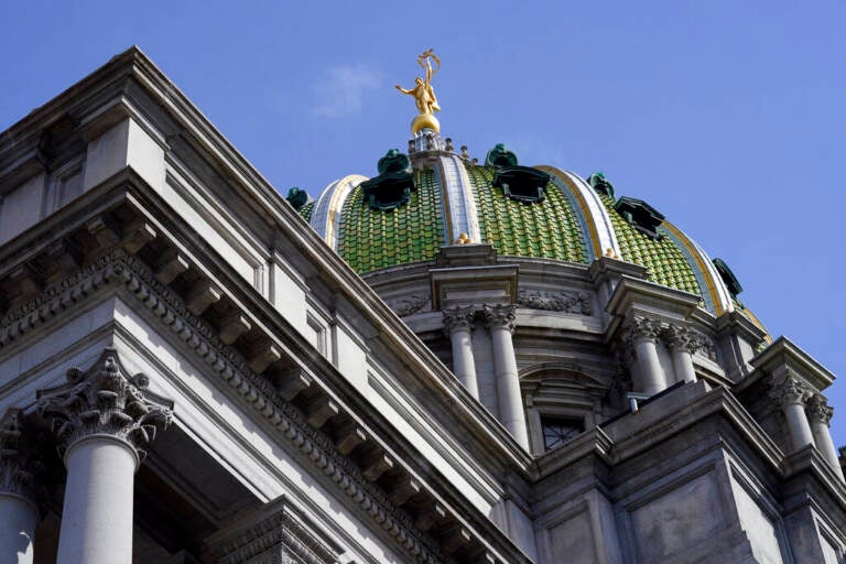 A view from below of the dome of the State Capitol building in Harrisburg, Pa., with blue sky in the background.