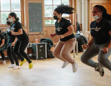 Girls jump in the air in a dance class.