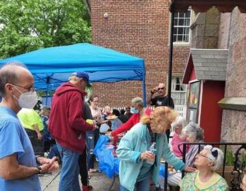 People gather together, talking and eating.