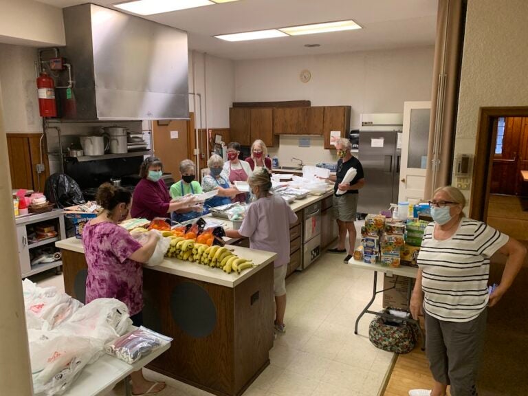 People cook together in a large kitchen.