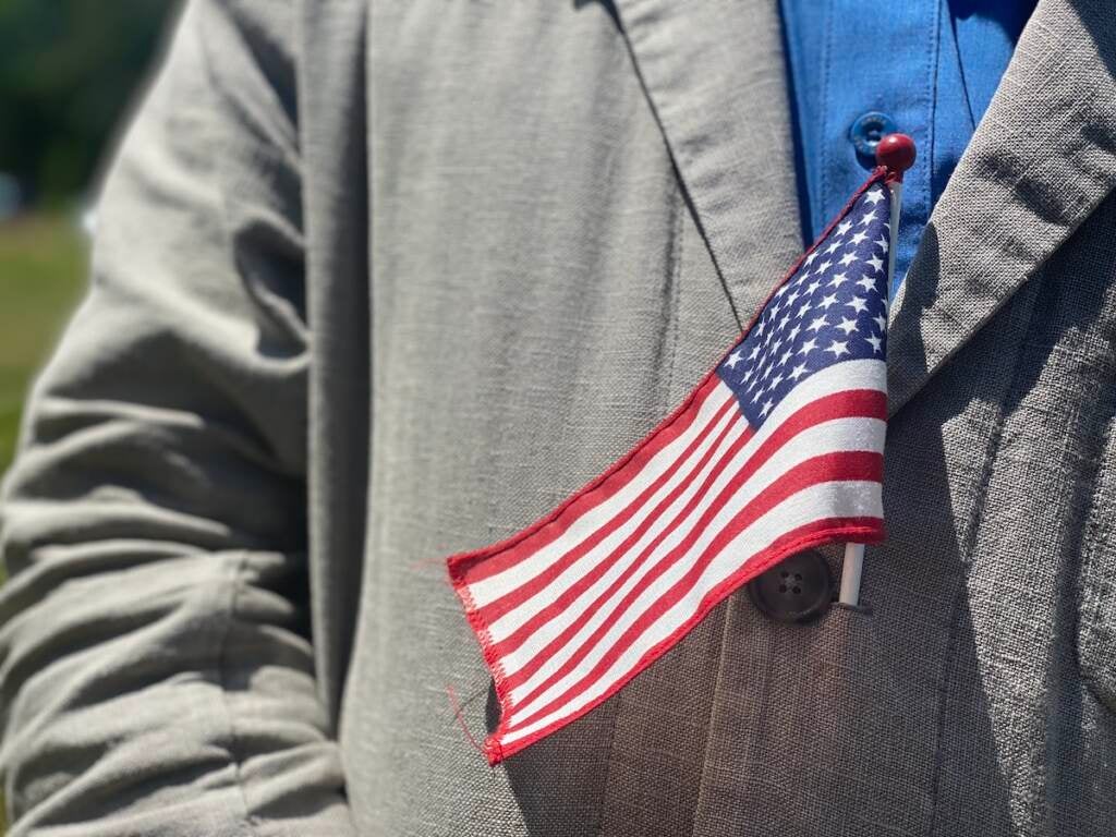 An upclose image of an American flag worn by someone in their jacket.