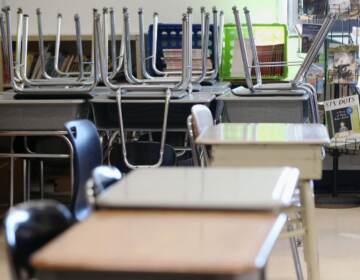 School desks are shown, with chairs stacked in the background.