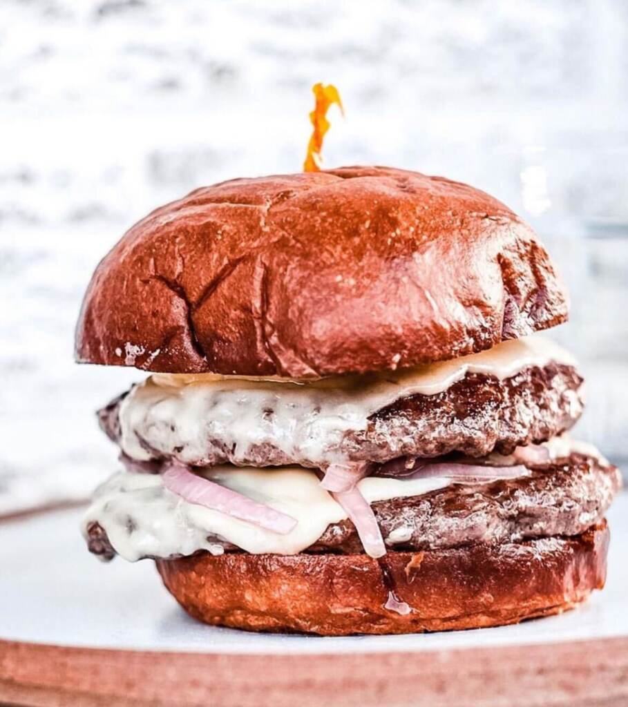 A close-up of a double patty burger at River Twice.