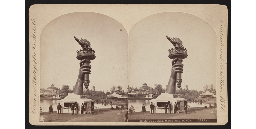 An old photograph shows the torch of the Statue of Liberty.