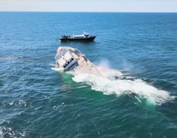 The Texas Star sinks into the ocean, foam rising up around it.