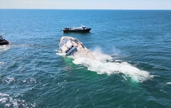 The Texas Star sinks into the ocean, foam rising up around it.