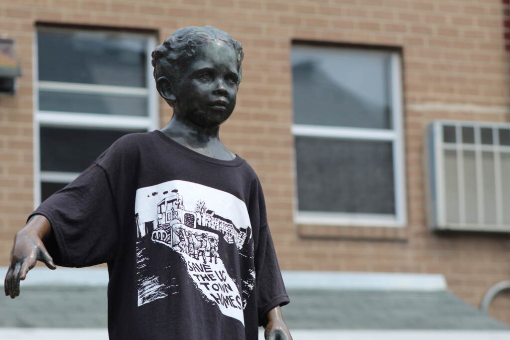 A statue is shown wearing a T-shirt.