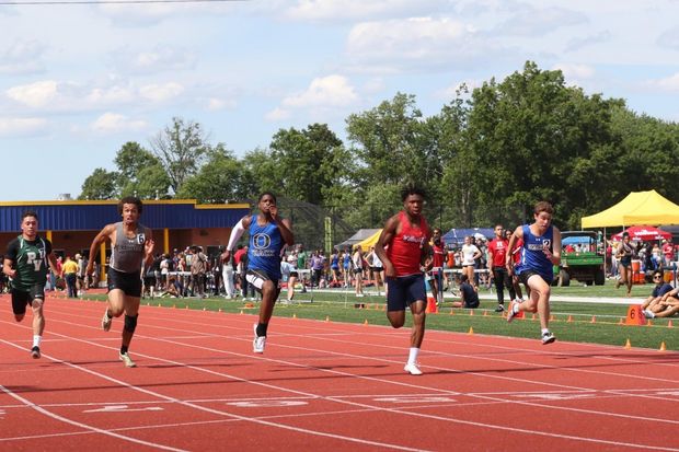 Track and field athletes run on a track.