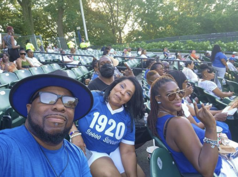 Three people smile for a photo at a re-Grand Boulé event at the Dell Music Center