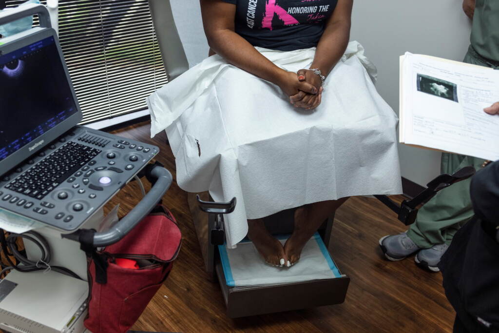 The clinic doctor at Houston Women's Reproductive Services discusses ultrasound results with a patient