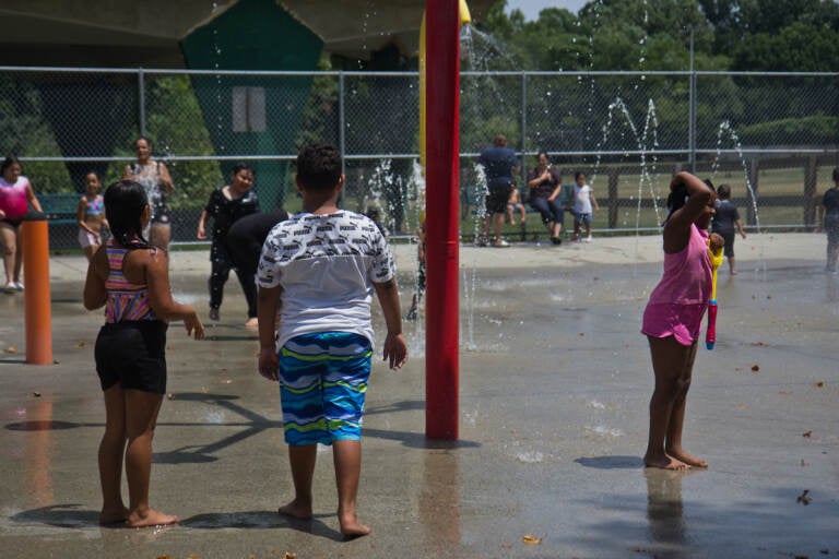 Families enjoy the sprinkler park at Ferko Playground