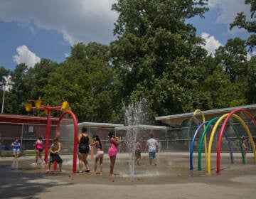 Families enjoy the sprinkler park at Ferko Playground