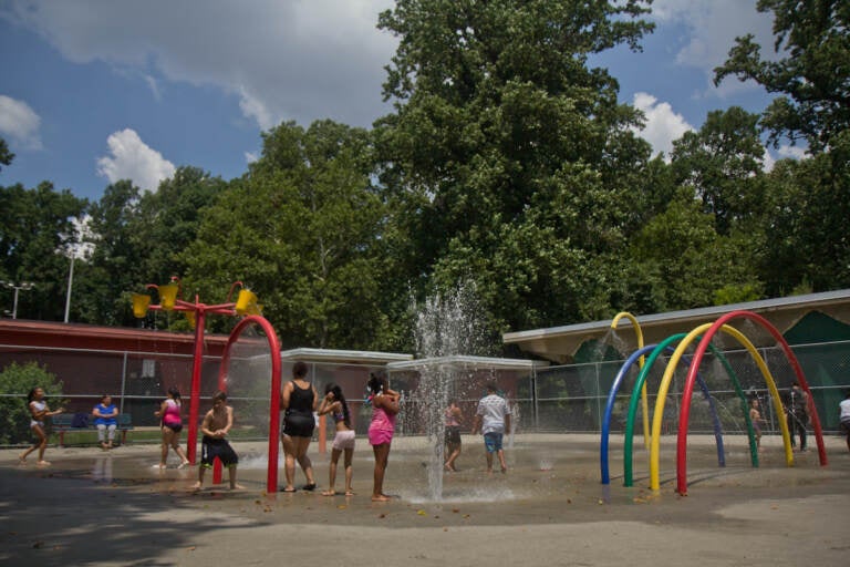 Families enjoy the sprinkler park at Ferko Playground