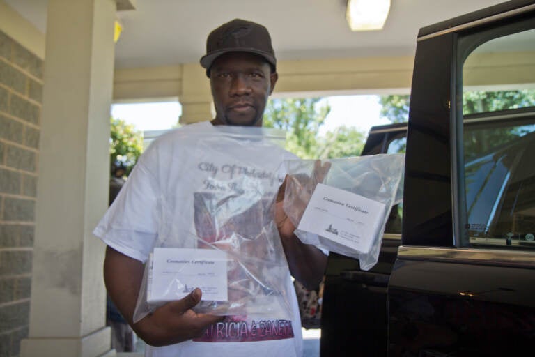 Lionel Dotson holds up a bag containing his sisters' remains