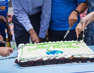 Climate activists held a celebration of the proposed Inflation Reduction Act and protest for more government action on climate change outside Sen. Bob Casey's office in Philadelphia on Aug. 5, 2022. (Kimberly Paynter/WHYY)