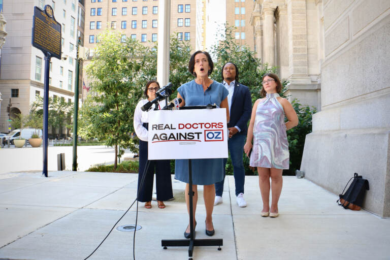 Dr. Val Arkoosh,(left), Chair of Montgomery County Board of Commissioners, speaks outside Philadelphia City Hall, where she helped launch the Real Doctors Against Oz campaign. The campaign is directed against Republican Senate candidate Mehmet Oz and is financed by his opponent, Democratic Lieutenant Gov. John Fetterman. (Emma Lee/WHYY)