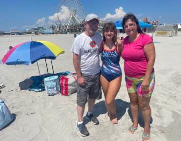 Cheryl Lozada (right) with her husband, Tom, and daughter, Leah, on the beach in Wildwood, N.J. on August 10, 2022. Lozada said she and her family have been vacationing here since Leah was a toddler adding that they were going to come regardless of the cost. (P. Kenneth Burns/WHYY)