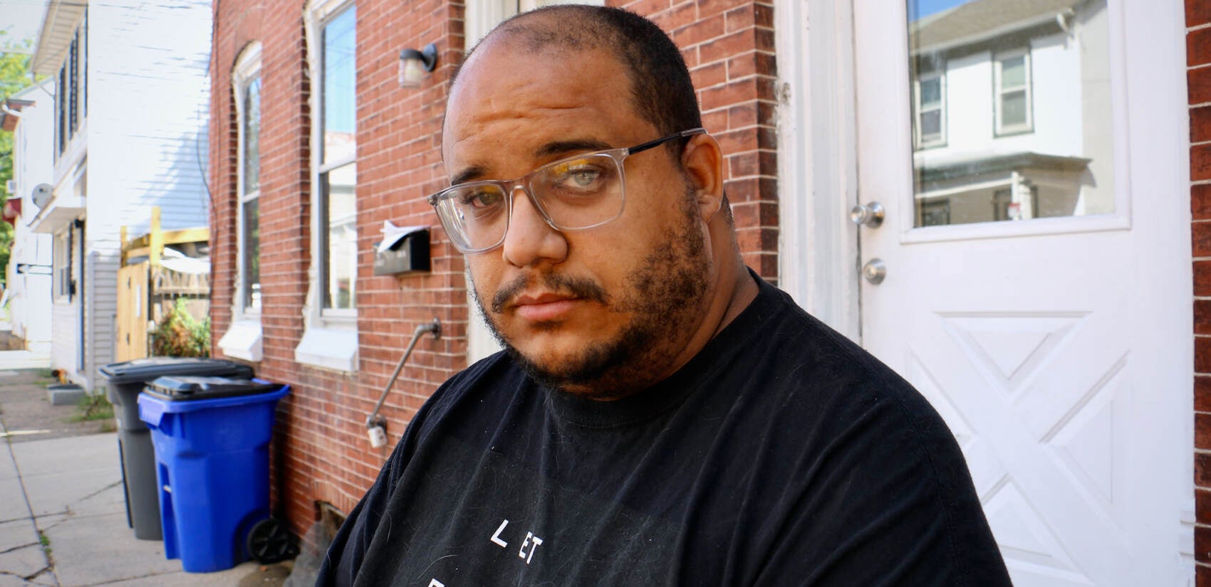 Eric Fagan stands on the stoop outside his apartment in Pottstown. He was displaced from Norristown a year ago by Hurricane Ida, which innundated his ground floor apartment and destroyed nearly everything he owned. (Emma Lee/WHYY)