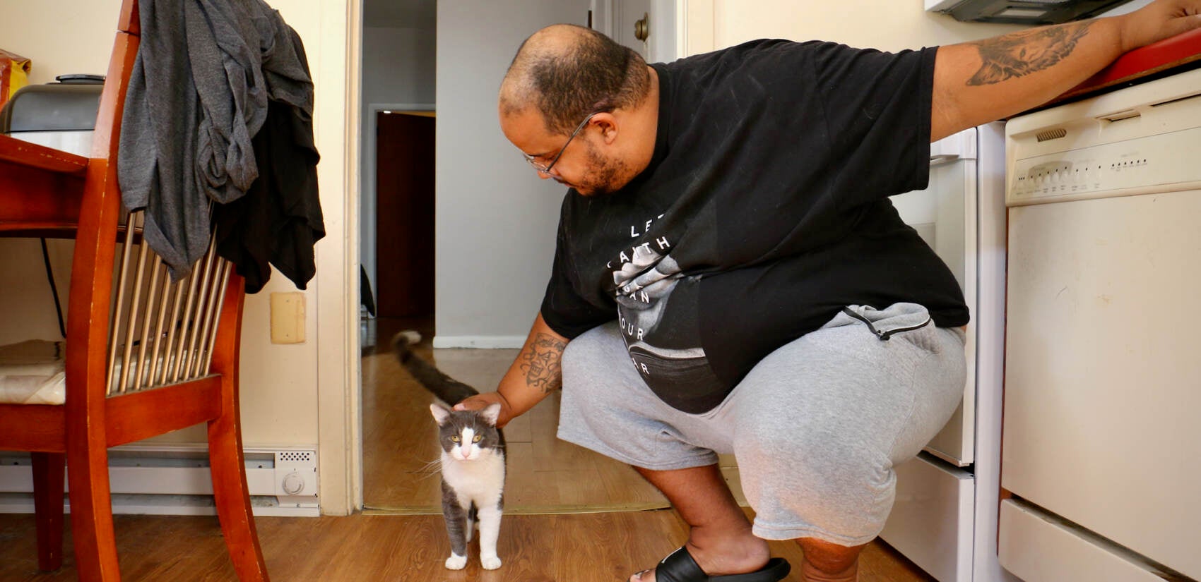 Eric Fagan with his cat, Scrappy, who was just a kitten when flooding from Hurricane Ida swamped their Norristown apartment. Fagan evacuated his elderly father to a hotel, then went back for Scrappy. (Emma Lee/WHYY)