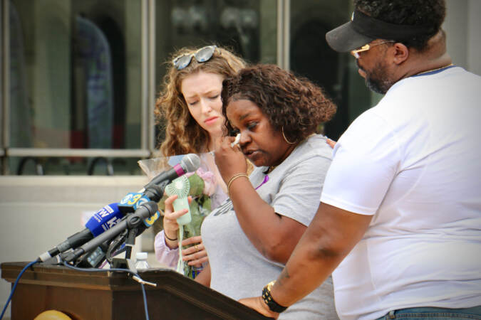 Kimberley Robinson-Presley wipes away tears as she talks about her daughter, Kimera Robinson, who died of an overdose in February of 2021. Robinson-Presley spoke at the opening ceremony for the Philadelphia Overdose Memorial Garden at Thomas Paine Plaza. (Emma Lee/WHYY)