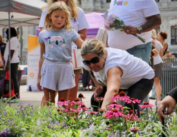 Mary Roth is comforted by her granddaughter, Stella Sniras, as she places a marker in the Philadelphia Overdose Memorial Garden for her son, Andrew Roth, who died of an overdose in July 2020.