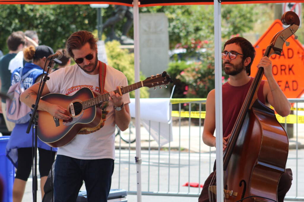 A person plays guitar and another person plays upright bass.