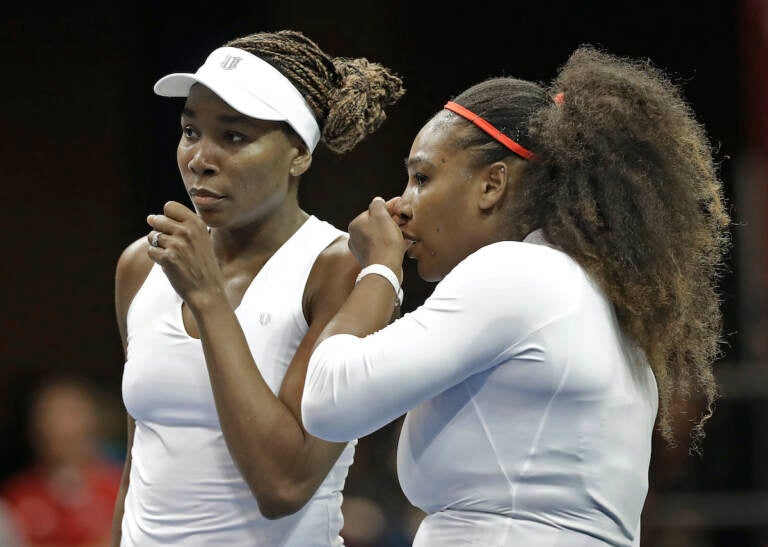  In this Sunday, Feb. 11, 2018, file photo, USA's Venus Williams (left) and Serena Williams (right) talk between points in their doubles match against Netherlands' Leslie Herkhove and Demi Schuurs in the first round of Fed Cup tennis competition in Asheville, N.C. (AP Photo/Chuck Burton, File)