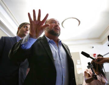 Alex Jones talks to media during a midday break during the trial at the Travis County Courthouse in Austin, Texas, Tuesday, July 26, 2022. An attorney for the parents of one of the children who were killed in the Sandy Hook Elementary School shooting told jurors that Jones repeatedly “lied and attacked the parents of murdered children” when he told his Infowars audience that the 2012 attack was a hoax. (Briana Sanchez/Austin American-Statesman via AP, Pool)