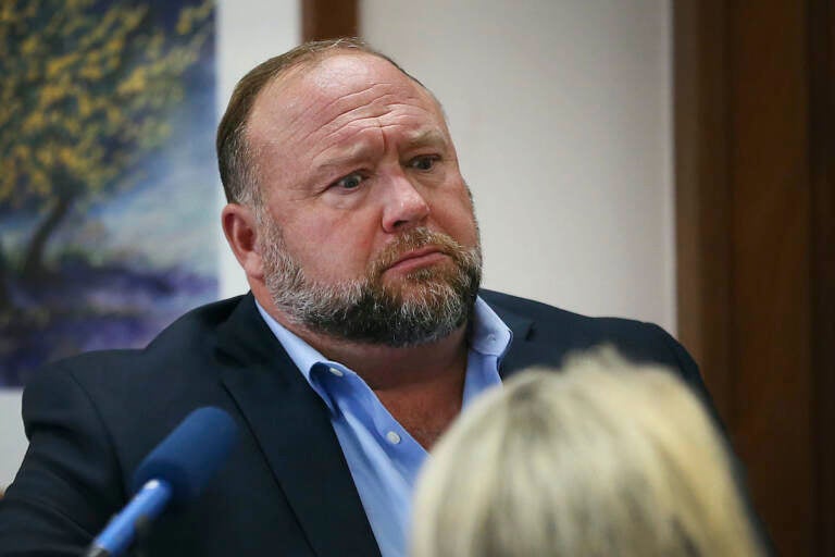Conspiracy theorist Alex Jones attempts to answer questions about his emails asked by Mark Bankston, lawyer for Neil Heslin and Scarlett Lewis, during trial at the Travis County Courthouse in Austin, Wednesday Aug. 3, 2022. (Briana Sanchez/Austin American-Statesman via AP, Pool)