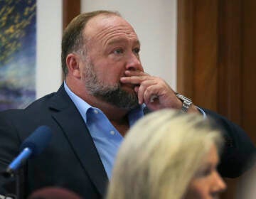 Alex Jones attempts to answer questions about his text messages asked by Mark Bankston, lawyer for Neil Heslin and Scarlett Lewis, during trial at the Travis County Courthouse in Austin, Wednesday Aug. 3, 2022. (Briana Sanchez/Austin American-Statesman via AP, Pool)