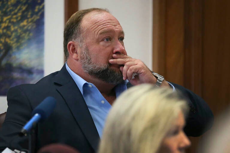 Alex Jones attempts to answer questions about his text messages asked by Mark Bankston, lawyer for Neil Heslin and Scarlett Lewis, during trial at the Travis County Courthouse in Austin, Wednesday Aug. 3, 2022. (Briana Sanchez/Austin American-Statesman via AP, Pool)