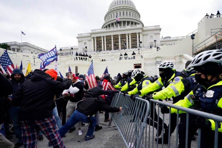 Rioters push a police barricade at the U.S. Capitol on Jan. 6, 2021.