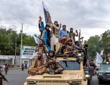 Taliban fighters celebrate one year since they seized the Afghan capital, Kabul, in front of the U.S. Embassy in Kabul, Afghanistan, Monday, Aug. 15, 2022. The Taliban marked the first-year anniversary of their takeover after the country's western-backed government fled and the Afghan military crumbled in the face of the insurgents' advance. (AP Photo/Ebrahim Noroozi)