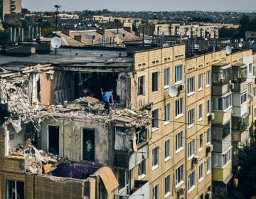 A man cleans an apartment destroyed after Russian shelling in Nikopol, Ukraine, Monday, Aug. 15, 2022. (AP Photo/Kostiantyn Liberov)